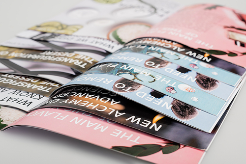 close up view of colorful magazines on grey background