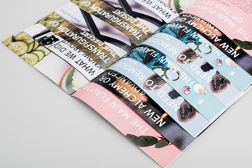 top view of several beauty magazines on grey background