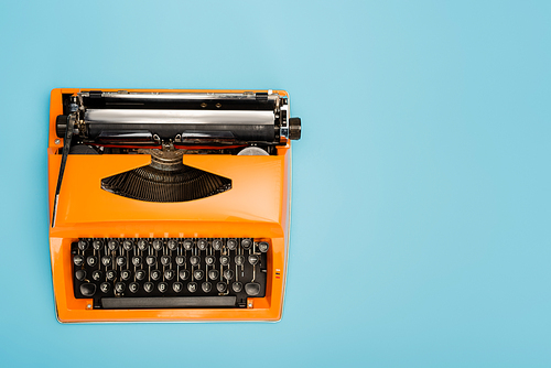 top view of vintage typing machine isolated on blue