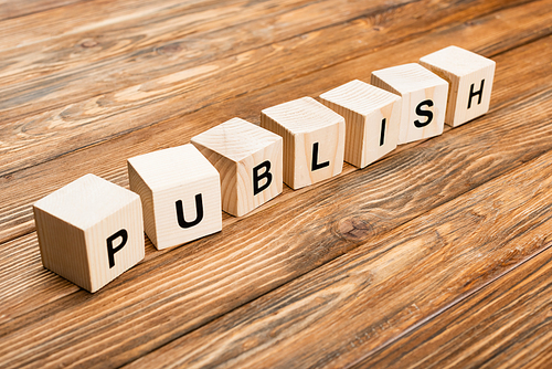 row of wooden cubes with publish lettering on brown textured surface