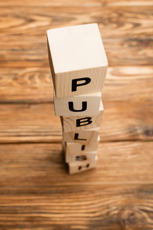 stacked cubes with word publish on blurred wooden surface