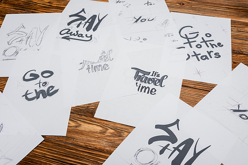 high angle view of papers with different fonts on wooden desk