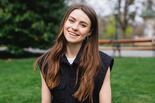 portrait of young cheerful woman in sleeveless jacket