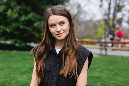 portrait of young pretty woman looking away in park