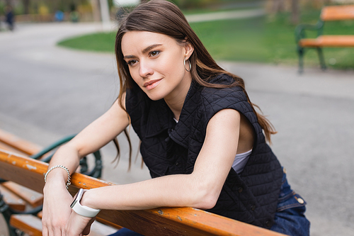 portrait of young pretty woman in sleeveless jacket leaning on handrail