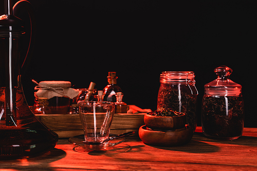 Hookah near dry tea and cup on wooden surface isolated on black