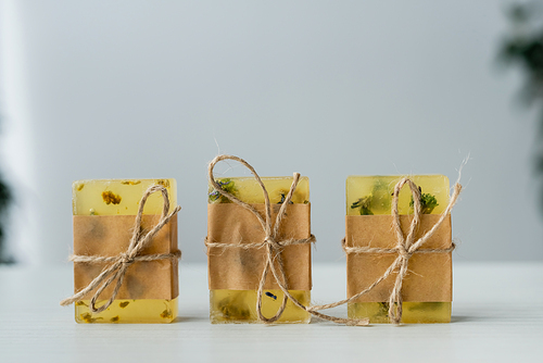 Close up view of handmade soap bars with craft paper and twine on table