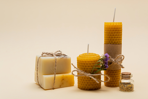 Craft soap near candles on beige background