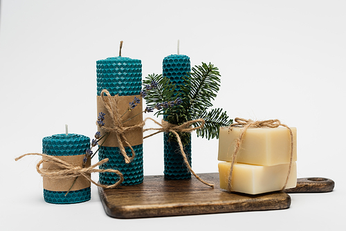 Handmade candles and soap on cutting board on grey background