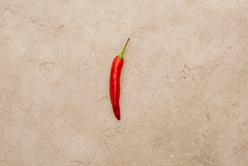 top view of red chili pepper on beige concrete surface