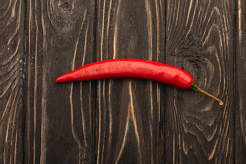 top view of spicy red chili pepper on wooden surface