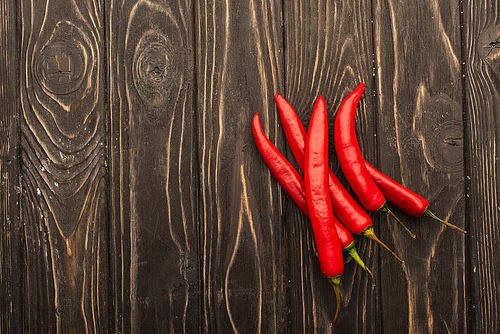 top view of chili peppers on wooden surface