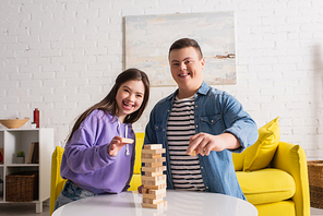 Happy friends with down syndrome  near wood blocks game at home