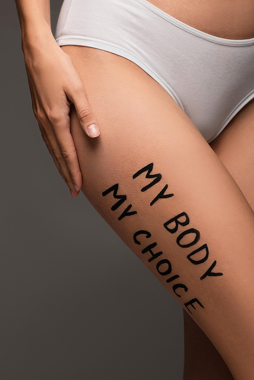 partial view of woman in panties, with my body my choice lettering on hip isolated on dark grey