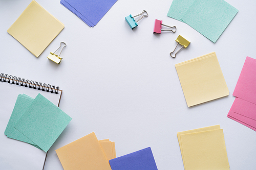 flat lay of colorful paper notes and fold back clips on white