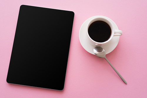 top view of digital tablet with blank screen near cup of coffee on pink