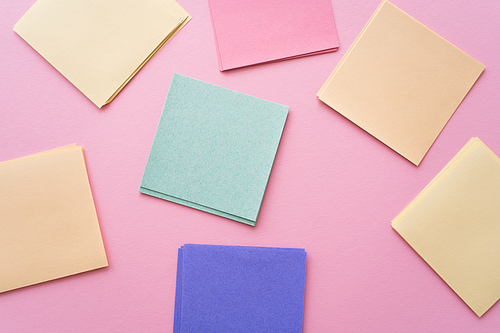 top view of colorful and blank paper notes on pink