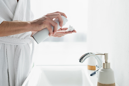 cropped view of man applying shaving foam on hand near sink in bathroom