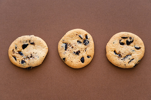 Top view of tasty cookies on brown background