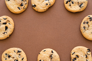 Top view of frame from cookies with chocolate chips on brown background