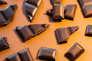 Top view of natural dark chocolate on brown background