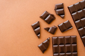 Top view of dark chocolate on brown background with copy space