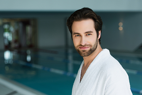Young man in white bathrobe  in spa center