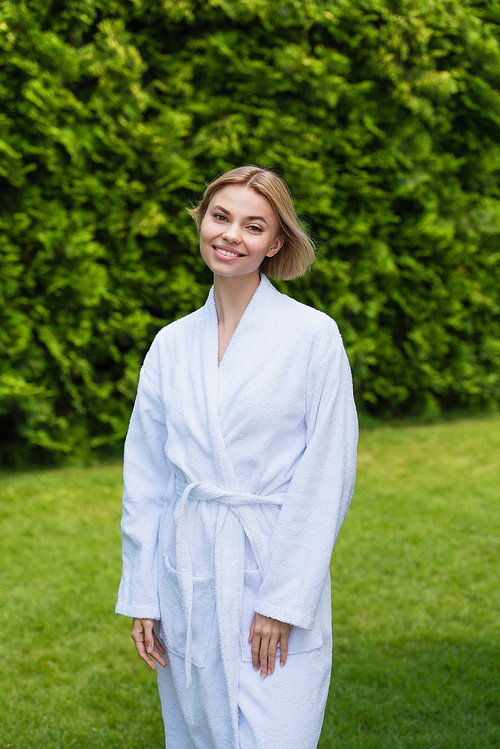 Smiling woman in white bathrobe  on resort