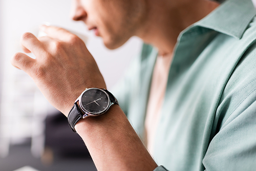 cropped view of man in wristwatch  coffee, concept of time management