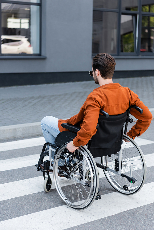 handicapped man moving on crosswalk in wheelchair
