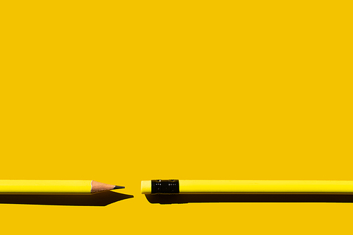 top view of sharp pencils and eraser on yellow background