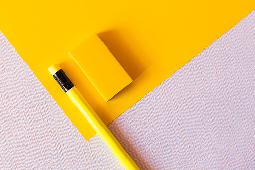 top view of pencil and eraser on yellow and white