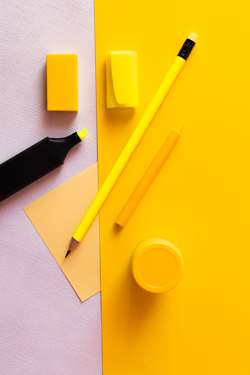 top view of stationery and marker pen near paper note on yellow and white