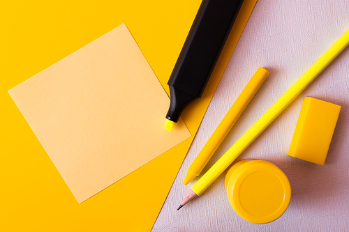 top view of stationery and marker pen near paper note on textured white and yellow