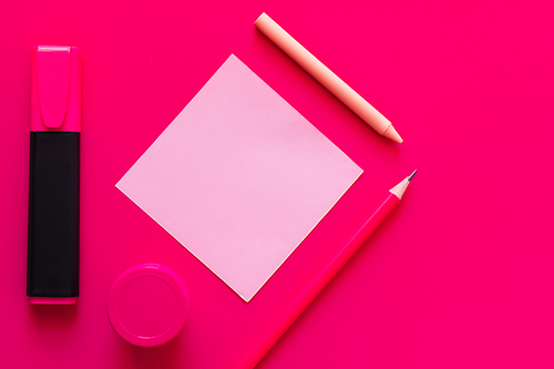 flat lay with stationery and jar with paint near paper note on pink