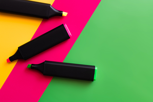 top view of colorful marker pens on multicolored background