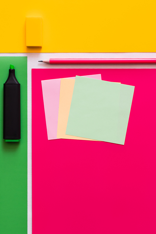 top view of stationery near paper notes on colorful background
