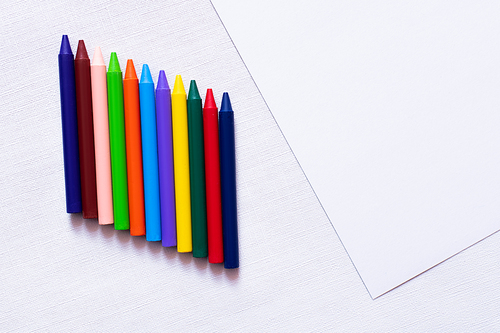 top view of colorful crayons on white textured background