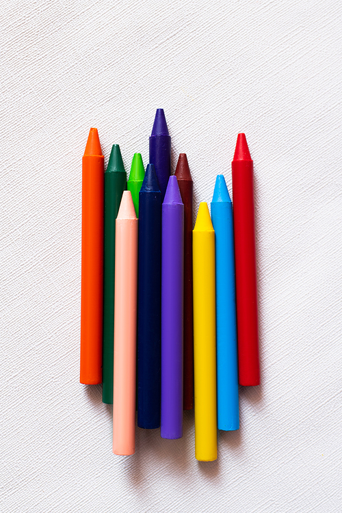 top view of colorful crayons on textured white background