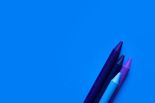 top view of gradient crayons on bright blue background