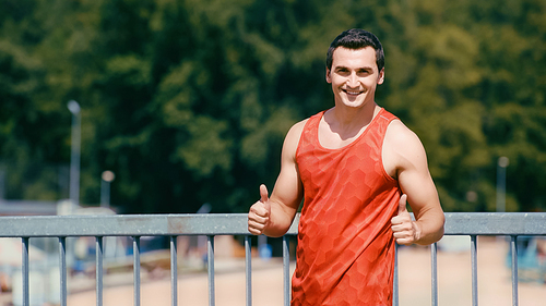 happy sportsman showing thumbs up on bridge