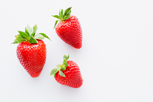 Top view of ripe strawberries with leaves on white background