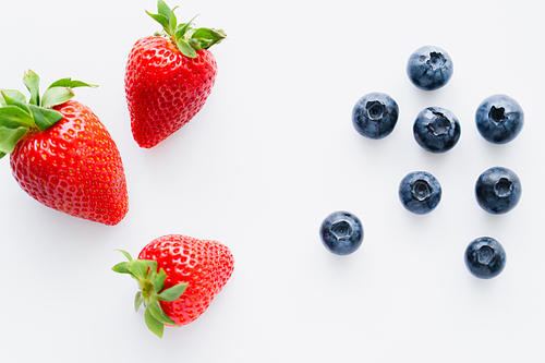 Top view of strawberries and blueberries on white background