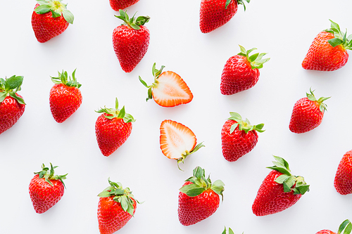 Flat lay with cut and whole strawberries on white background