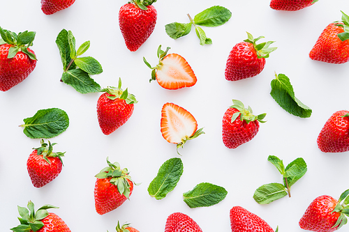 Top view of fresh strawberries and mint leaves on white background