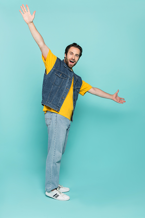 Excited man pointing with hands on blue background