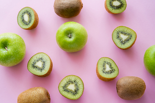top view of green apples and kiwi on pink