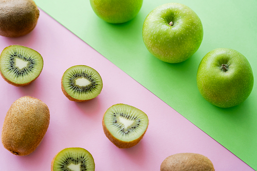 high angle view of rows with apples and kiwi fruits on green and pink