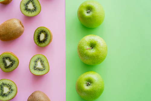 top view of rows with apples and kiwi fruits on green and pink
