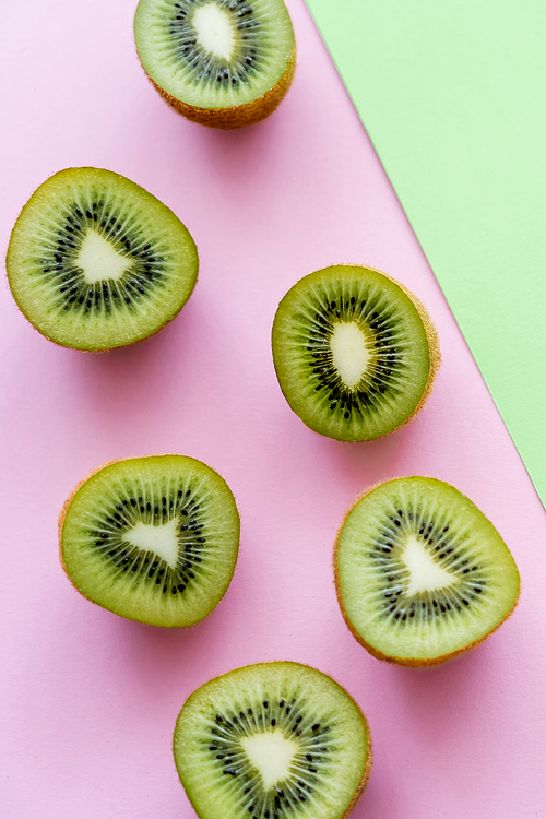top view of halves with fresh kiwi fruit on green and pink
